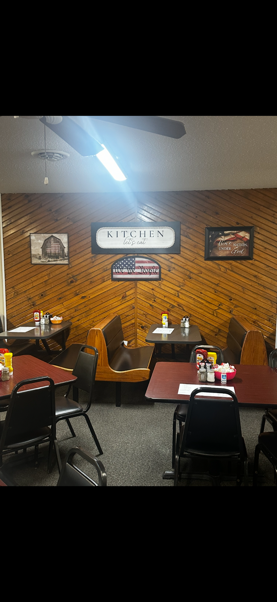 Inside dining area of 9th Street Cafe with tables, chairs, and wood walls